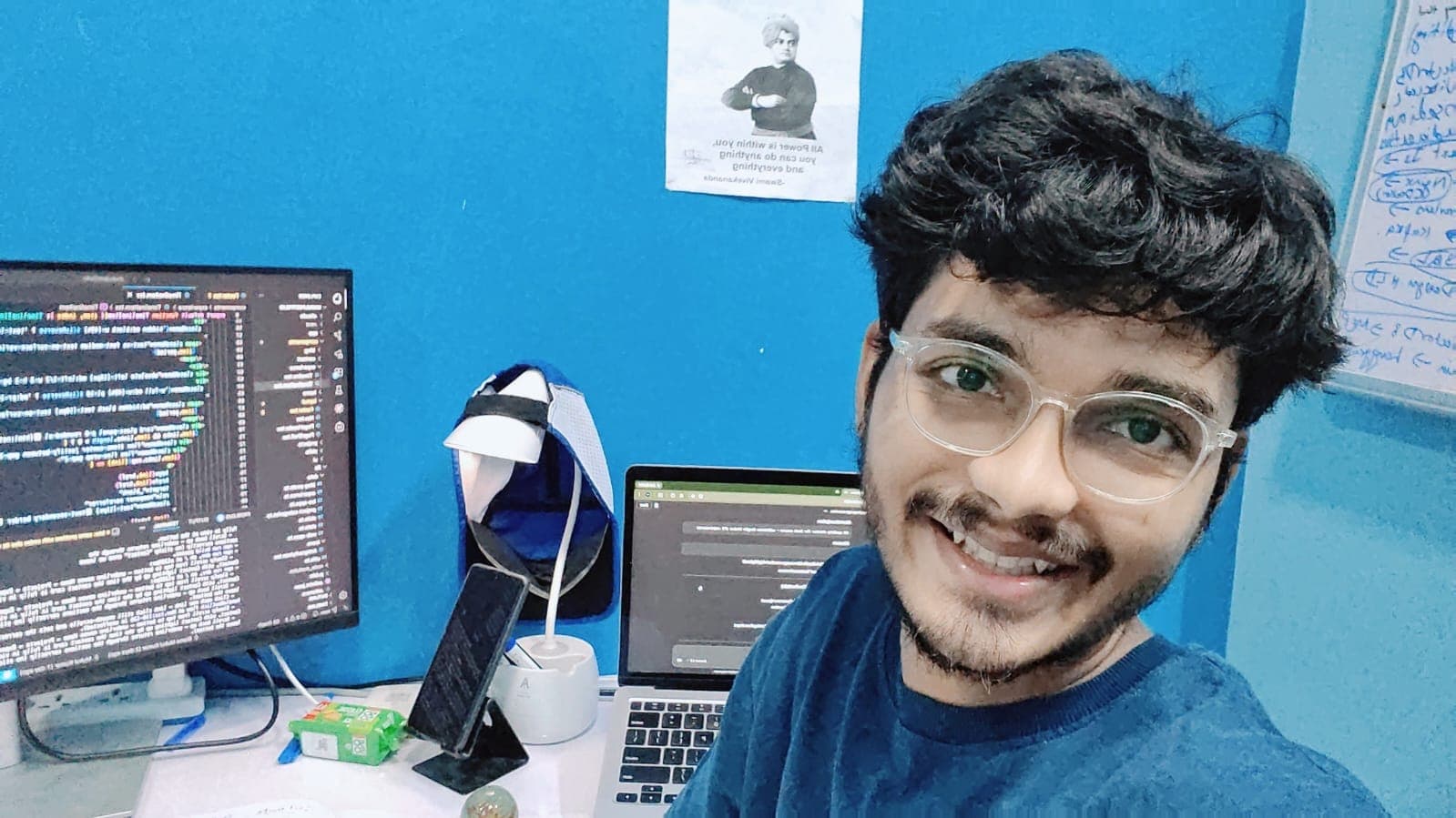 Author at his desk with code on a monitor — the working setup behind the year-long grind